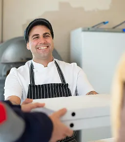Chef holding pizza boxes ready for delivery